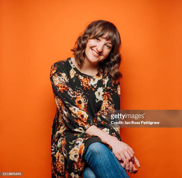 smiling young woman on orange background - fashion orange colour stock pictures, royalty-free photos & images