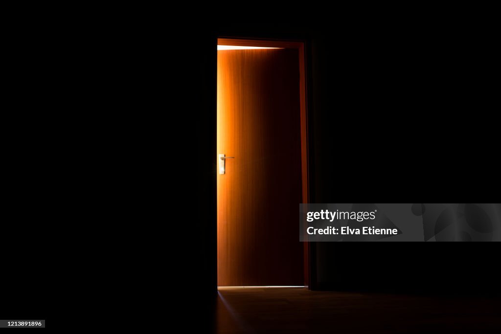 Glowing sunlight illuminating the edges of an opening interior door