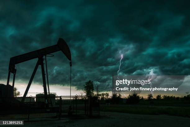 double lightning strikes with oil pump, taken near edmond, oklahoma. usa - oklahoma stock pictures, royalty-free photos & images