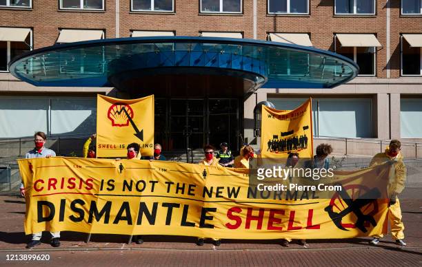 Environmental activists gather outside the Shell building to protest against fossil fuels as Shell holds its annual shareholders meeting on May 19,...