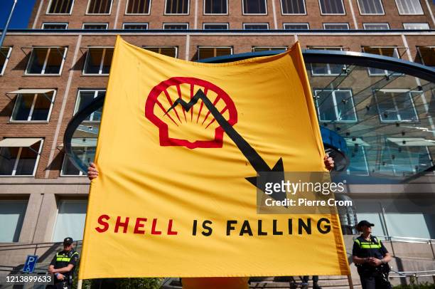 Environmental activists gather outside the Shell building to protest against fossil fuels as Shell holds its annual shareholders meeting on May 19,...