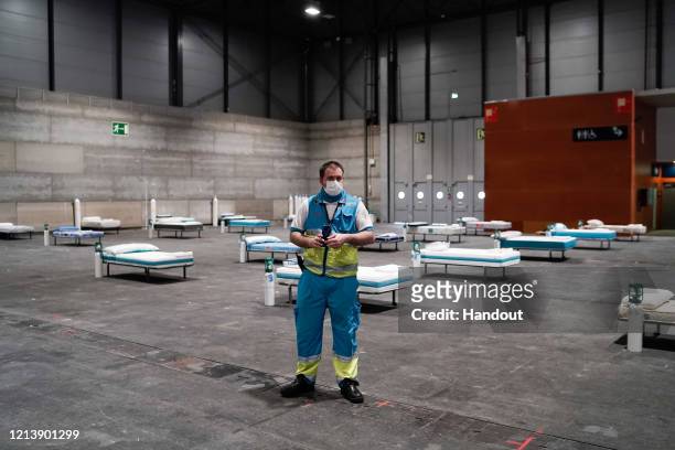 In this handout from the Comunidad de Madrid, workers install a field hospital for coronavirus patients in Ifema on March 21, 2020 in Madrid, Spain....