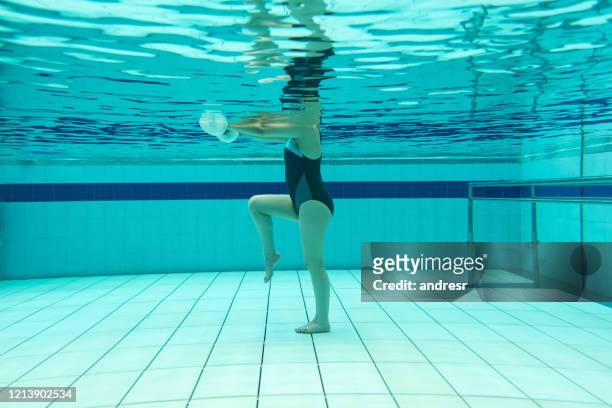 underwater shot of a woman doing physiotherapy exercises in the water - hydrotherapy stock pictures, royalty-free photos & images