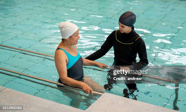 woman exercising in the water as part of her physical therapy - hydrotherapy stock pictures, royalty-free photos & images