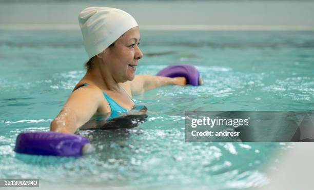 volwassen vrouw in hydrotherapie die oefeningen voor haar rug doet - hydrotherapie stockfoto's en -beelden