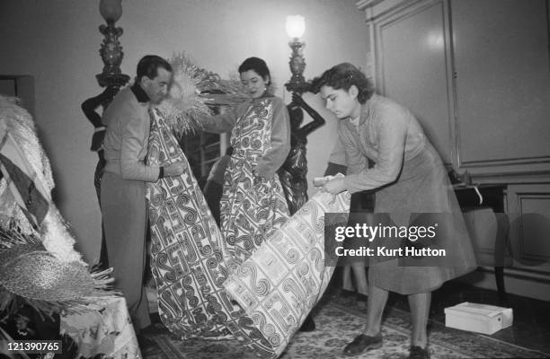 Italian fashion designer Emilio Pucci examines a roll of patterned fabric in Florence, Italy, 1952. Original Publication : Picture Post - 5685 -...