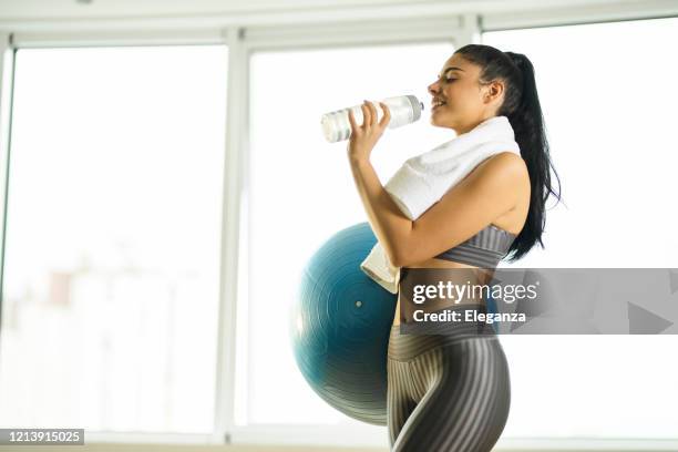 frau hält sportball und trinkwasser - protein balls stock-fotos und bilder