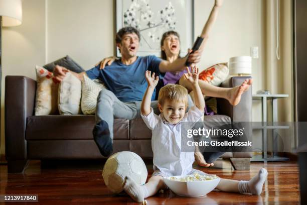 familia juntos viendo el fútbol en la sala de estar - futbol argentino fotografías e imágenes de stock