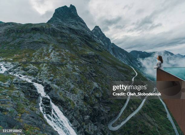 vrouw die trollstiegen in mist bekijkt - romsdal in norway stockfoto's en -beelden