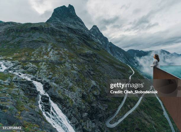 woman looking at trollstiegen in fog - romsdal stock pictures, royalty-free photos & images
