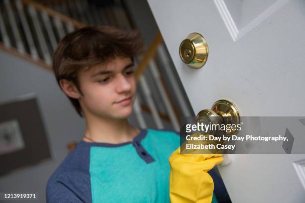 boy wiping doorknob with wet wipe - lakeville minnesota stock pictures, royalty-free photos & images