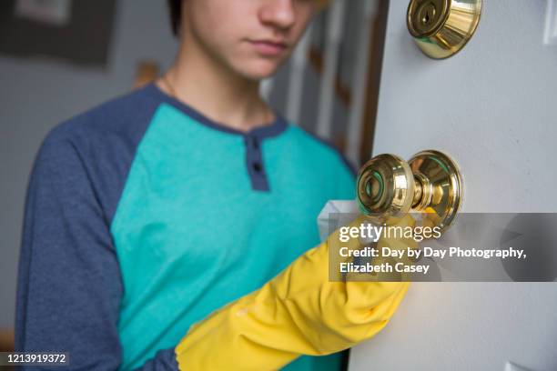 boy wiping doorknob with wet wipe - lakeville minnesota stock pictures, royalty-free photos & images