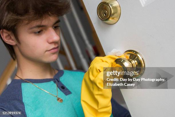 boy wiping doorknob with wet wipe - lakeville minnesota stock pictures, royalty-free photos & images