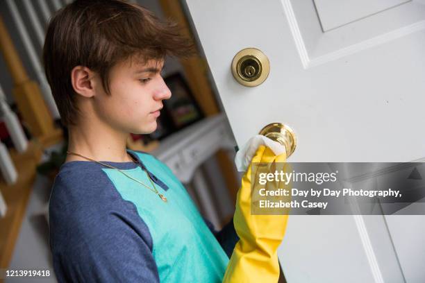 boy wiping doorknob with wet wipe - lakeville minnesota stock pictures, royalty-free photos & images