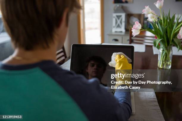 boy wiping computer monitor - lakeville minnesota stock pictures, royalty-free photos & images