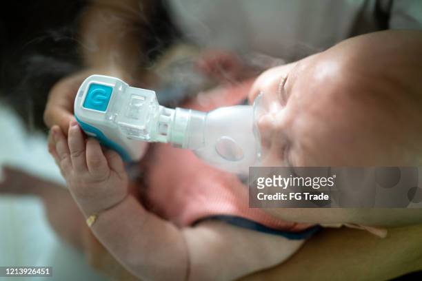 de therapie van de inhalatie van de baby door het masker van inhalator - zichtbare adem stockfoto's en -beelden