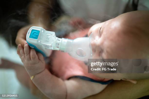 baby boy inhalation therapy by the mask of inhaler - inhaling smoke stock pictures, royalty-free photos & images