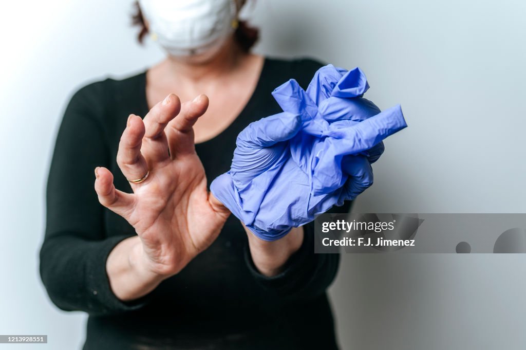 Close-up of woman's hands taking off disposable gloves