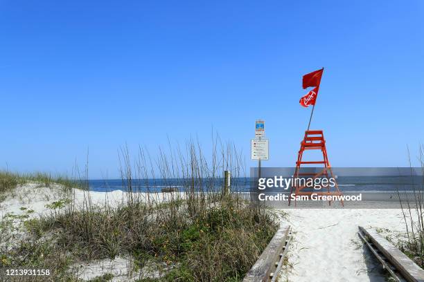 An empty lifeguard chair with a "No Swimming " flag is seen at Jacksonville Beach amid the coronavirus outbreak on March 21, 2020 in Jacksonville...