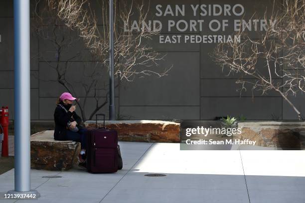 Traveler sits down outside the U.S. Customs and Border Protection - San Ysidro Port of Entry on March 21, 2020 in San Diego, California. The United...