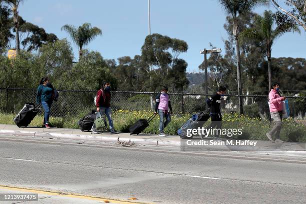Family walks towards the U.S. Customs and Border Protection- San Ysidro Port of Entry on March 21, 2020 in San Diego, California. The United States...