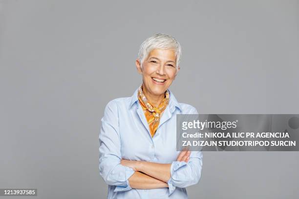 donna anziana felice su sfondo grigio. - formal portrait foto e immagini stock