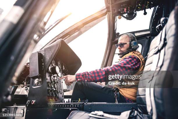 man inside a helicopter cabin - helicopter pilot stock pictures, royalty-free photos & images