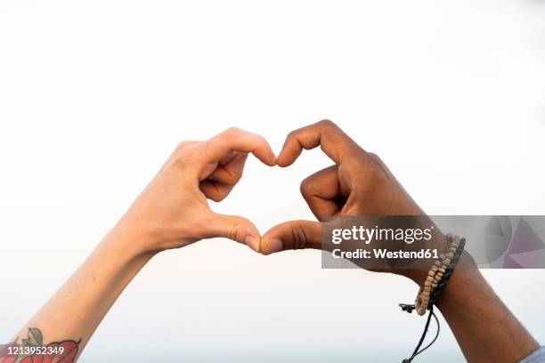 close-up of two hands shaping a heart - heart bracelet stock pictures, royalty-free photos & images