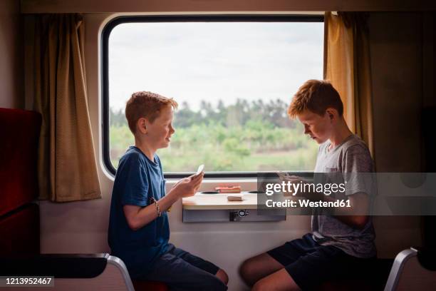 side view of boys playing cards while traveling in train, thailand, asia - travelgame stock pictures, royalty-free photos & images