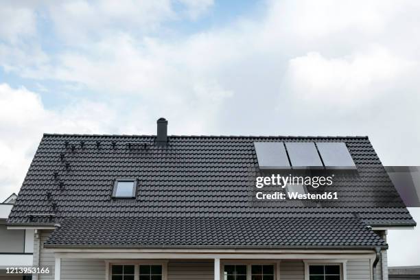 rooftop of one-family house with three solar panels, germany - einfamilienhaus mit solarzellen stock-fotos und bilder