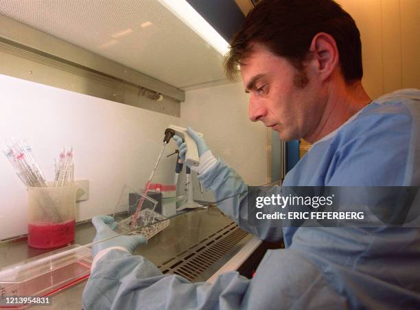 Le généticien Pierre Charneau, chercheur à l'Institut Pasteur, effectue une manipulation, le 04 mai 2000 à Paris, dans l'unité d'oncologie virale...