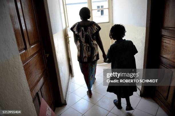 Ten-year-old girl who was raped twice in the last ten days is lead by the hand by a counselor at a Congolese non-government organization on the day...
