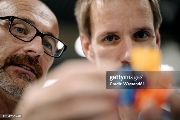 two men examining workpiece in a factory - product design stock-fotos und bilder