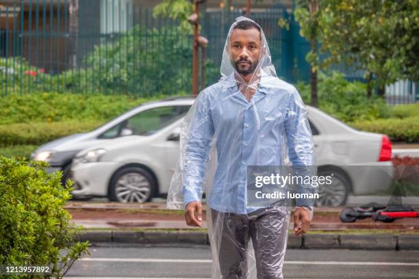 black brazilian man walking on a rainy day - rainy day in sao paulo stock pictures, royalty-free photos & images