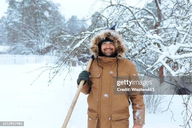 portrait of smiling man with snow shovel - snow shovel man stock pictures, royalty-free photos & images