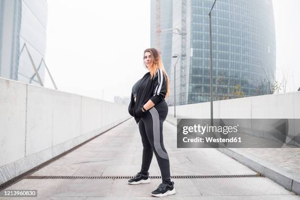 plus size sportive young woman posing in the city - black pants woman fotografías e imágenes de stock