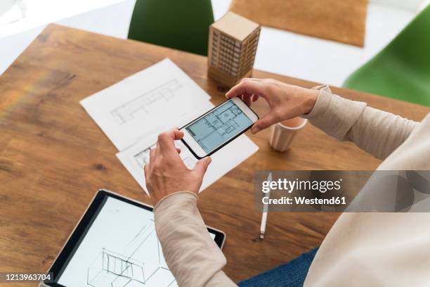close-up of woman in architectural office taking cell phone picture of construction plan - modelo arquitetônico - fotografias e filmes do acervo