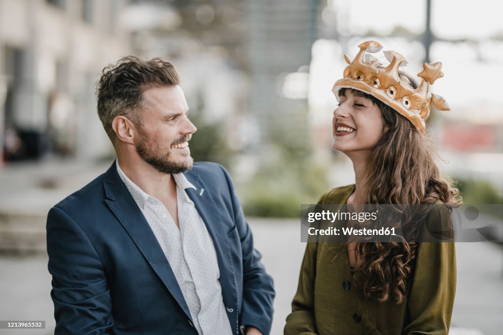 Smiling businessman looking at woman wearing a crown