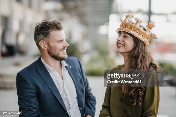 smiling businessman looking at woman wearing a crown - woman crown stock pictures, royalty-free photos & images
