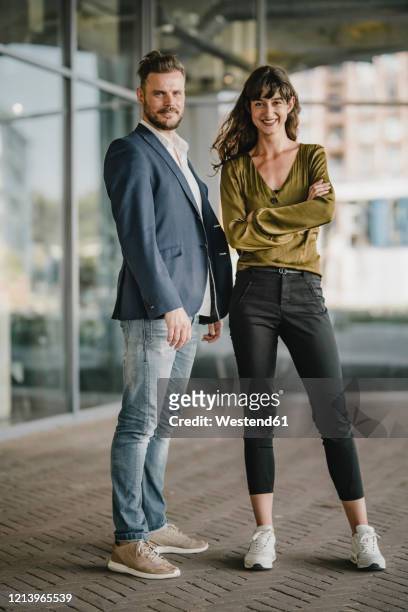 portait of smiling businessman and casual businesswoman outdoors - tossing hair facing camera woman outdoors stock pictures, royalty-free photos & images