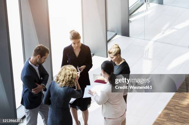 business people standing in modern office building discussing project - people business meeting birdseye stock pictures, royalty-free photos & images