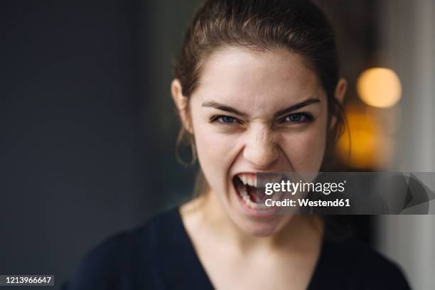 portrait of screaming young woman - enfado fotografías e imágenes de stock