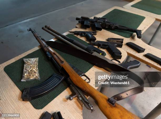 guns on the table in shooting range - gun stock pictures, royalty-free photos & images