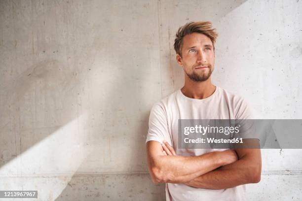 portrait of young man wearing t-shirt looking up - wegsehen stock-fotos und bilder