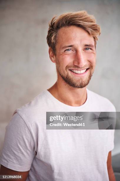 portrait of happy young man wearing white t-shirt - young man blue eyes stock pictures, royalty-free photos & images