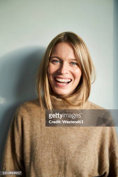 portrait of laughing blond young woman - lachen stock-fotos und bilder