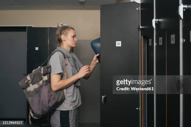 young woman in locker room of a boxing club - sports equipment locker stock pictures, royalty-free photos & images