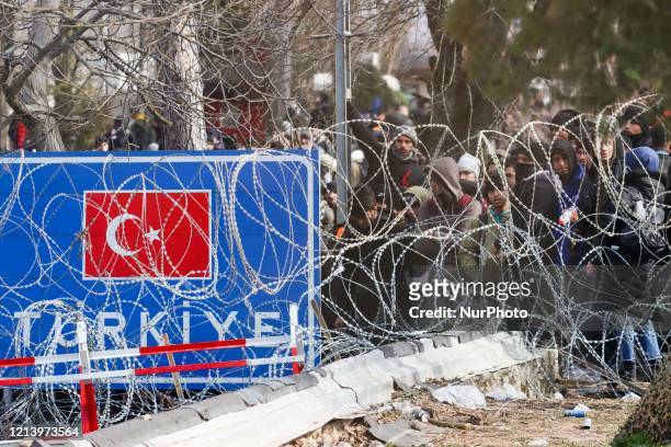 Sign with the Turkish flag and migrants who want to enter illegally into Greece while the protest. Migrant groups at Pazarkule and Kastanies border...