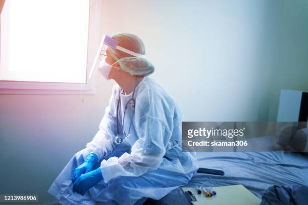 doctor wearing ppe (personal protection equipment ) or isolation grown suite  feeling down and sad for fighting  covid-19 (corona virus) - protective workwear stock pictures, royalty-free photos & images