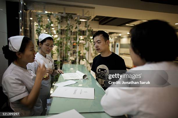 Chinese man speaks with nurses after undergoing a rhinoplasty procedure at the Shisanba Cosmetic Surgery Hospital May 12, 2011 in Beijing, China. The...